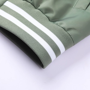 Detailed close-up of ribbed cuffs with white stripes on sage green bomber jacket sleeve