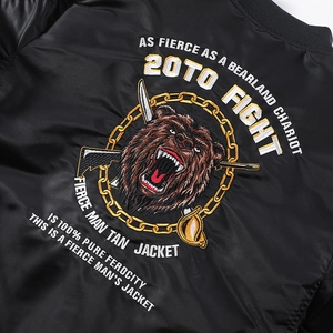 Broderie détaillée d'un ours avec des armes sur un blouson aviateur en satin noir
