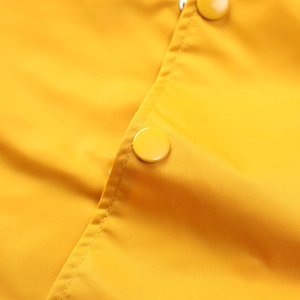 Close-up of high-quality nylon fabric texture and matching resin buttons on flight jacket