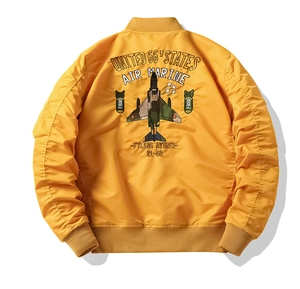 Detail of military-style fighter jet embroidery on a yellow nylon bomber jacket
