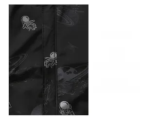 Detail of space-themed embroidery featuring an astronaut and planet on a black jacket