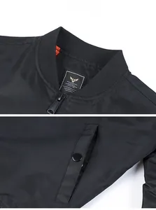 Detail of black bomber jacket with orange lining, ribbed collar, and snap pocket