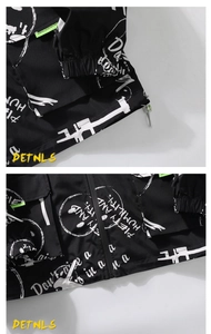 Détails d'une veste urbaine noire avec imprimé graffiti blanc et ruban vert fluo