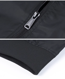 Detailed close-up of a black bomber jacket showing premium metal zipper and ribbed cuffs
