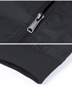 Detailed macro view of high-quality metal zipper and ribbed cuffs on black flight jacket