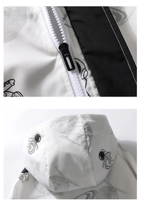 Detail of white hooded jacket featuring astronaut prints and a smooth nylon zipper