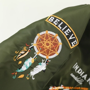 Army green bomber jacket featuring intricate colorful embroidery and ethnic patches