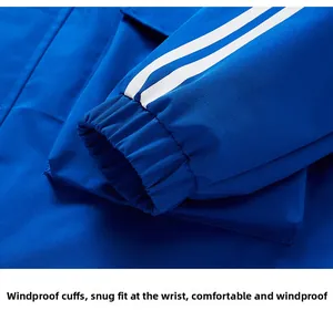 Detail of blue windbreaker jacket showing elastic windproof cuffs with triple white stripes