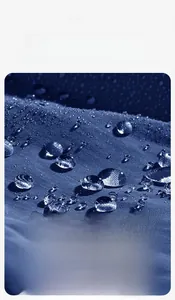 Macro detail of blue waterproof fabric showing water droplets on outdoor jacket surface