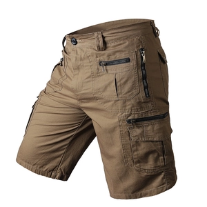 Detailed macro view of khaki cotton cargo shorts featuring side pockets and metal zippers