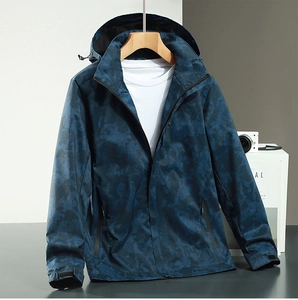 Detail of waterproof camouflage jacket with adjustable hood and velcro cuffs on a hanger