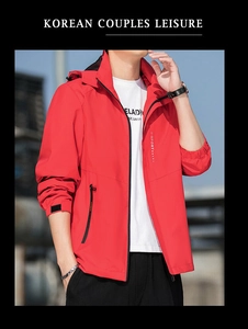 Detail of red windproof hiking jacket featuring waterproof zipper pocket and hood