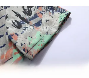 Close-up of short sleeve cuff featuring abstract graffiti print and neat stitching detail