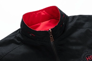 Detail of men's black standing collar jacket featuring red contrast lining and embroidery