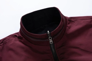 Detail view of burgundy stand-up collar with ribbed knit edge and metallic zipper