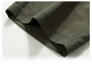 Detailed close-up of olive cargo shorts hem with durable double-needle stitching