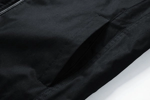 Detailed macro view of black jacket side pocket and smooth zipper stitching