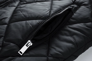 Close-up of diamond quilted jacket fabric with silver metal zipper pocket detail