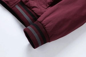 Close-up of burgundy cotton jacket with ribbed striped cuffs and high-quality stitching