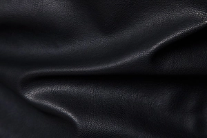 Macro view of black lychee grain leather texture on men's stand collar biker jacket