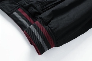 Detail of ribbed hem and cuffs with contrast stripes on black washed cotton jacket