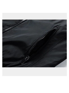 Detail of the metal zipper pocket and windproof fabric texture on the black jacket