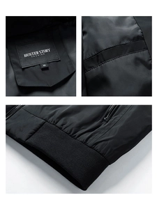 Detail view of black windproof jacket featuring brand label and elastic ribbed hem craftsmanship