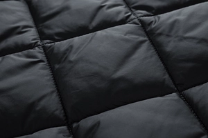 Close-up detail of black quilted diamond stitching fabric on men's winter jacket