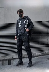 Detail der schwarzen Techwear-Hose und Kapuzenjacke mit modischen Streetwear-Prints