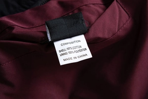 Detail view of cotton jacket care label showing fabric composition and material quality