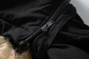 Macro detail of the metal zipper and thick faux fur lining on a black winter jacket