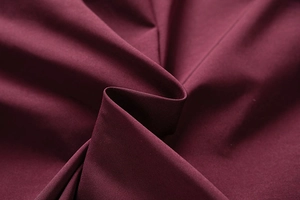 Detail view of premium washed cotton fabric texture and weight in dark burgundy