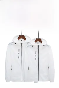 Détail de la veste de protection solaire blanche avec logo UPF 70 plus et capuche