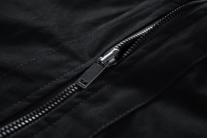 Macro shot of high-quality metal zipper and durable stitching on a black casual jacket