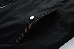 Detail of men's jacket pocket with striped webbing and silver metallic snap button