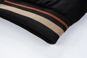 Close-up of black bomber jacket with striped elastic rib-knit cuffs and hem detail