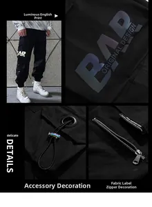 Detail of reflective BAR logo print and tactical pockets on black techwear cargo pants