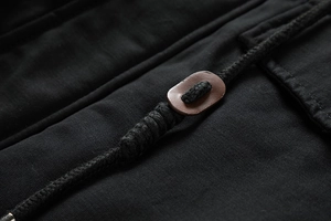 Makrodetail der Kapuzenjacke mit gewebtem Kordelzug, Lederknebel und Metallkappe