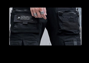 Detail der Herren-Cargohose in Schwarz mit Multi-Taschen-Design und dekorativem Webetikett