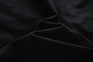 Macro shot of black washed jacket fabric showing dense matte texture and soft drape