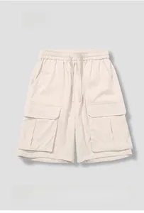 Detail of light beige cargo shorts featuring elastic drawstring waist and side flap pockets