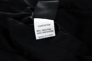 Detailed close-up of garment wash label showing 100% cotton composition and care instructions