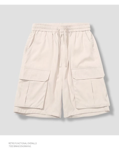 Detailed view of elastic waistband and large flap cargo pockets on khaki shorts