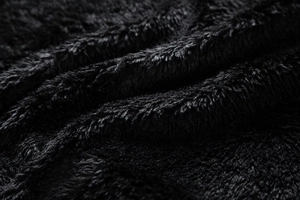 Detailaufnahme des dicken schwarzen Kunstpelzfutters einer Winterjacke mit weicher Textur