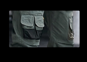 Detail einer olivgrünen Cargohose mit funktionalen schwarzen Mesh- und Klappentaschen