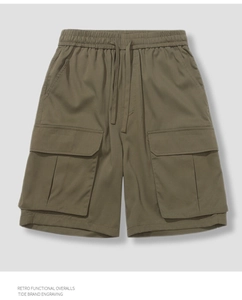 Detailed close-up of olive green cargo shorts with elastic drawstring waist and side pockets