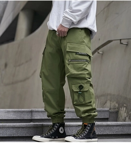 Detail of military green cargo pants featuring multi-pockets and drawstring ankle cuffs