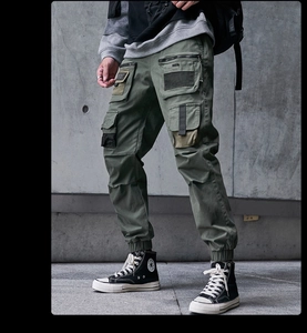 Details der armeegrünen Techwear-Cargohose mit mehreren Taschen und elastischen Bündchen