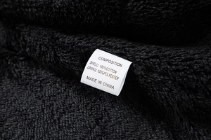 Detailansicht von Baumwolloberstoff und Polyester-Fleece-Futter mit Waschetikett
