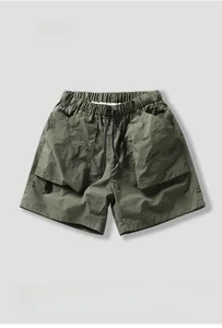 Detailed view of cargo shorts with elastic drawstring waist and large pockets in olive green